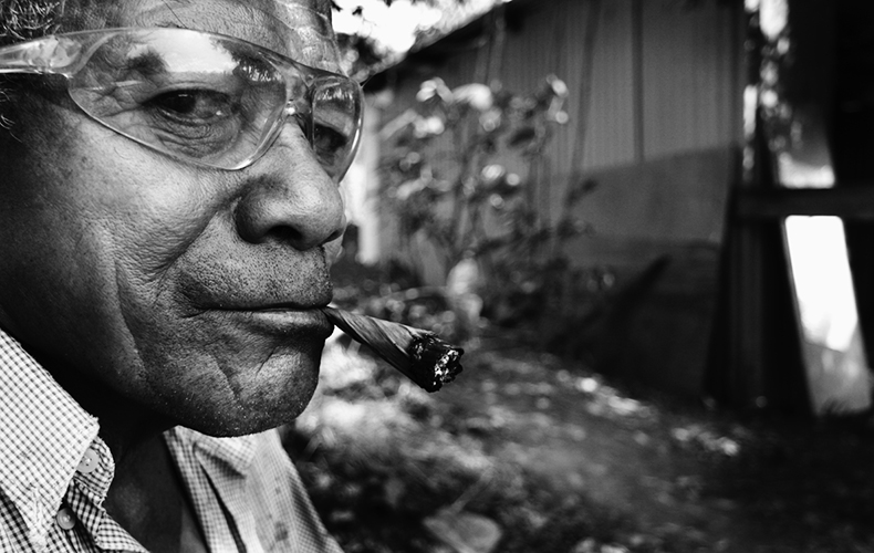 Faire une pause - Près du champ que cultive le groupe d’amis, Jean Soane prend une pause en fumant du tabac wallisien.