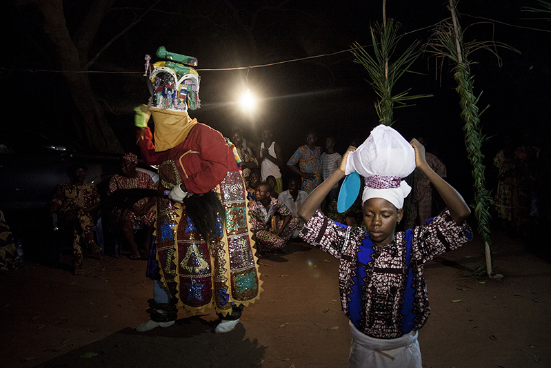 La jeune porteuse de calebasse dansera aux côtés d'Oro Efe, sans sourire. Elle symbolise la présence des mères, qui veillent. Ofia, Bénin, 2017. ©Laeïla Adjovi