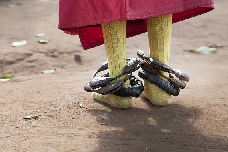 Lors de ces danses effectuées pour célébrer les esprits de 'nos mères', figures féminines des ancêtres, les costumes et les masques sont portés par des hommes ou de jeunes garçons. Leur accoutrement est composé le plus souvent d'un costume de couleur rouge, d'un tissu jaune ou blanc pour cacher leur visage, et de grelots aux chevilles. Ofia, Bénin, 2017. ©Laeïla Adjovi